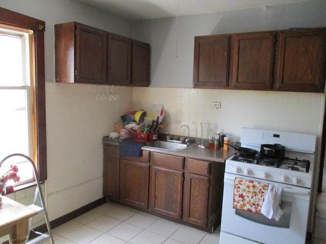 1525 Gunderson Ave, Berwyn, IL 60402 - kitchen with white gas range, healthy amount of natural light, a sink, and brown cabinets