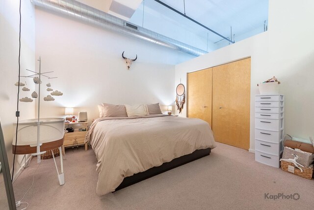bedroom featuring light carpet and a closet