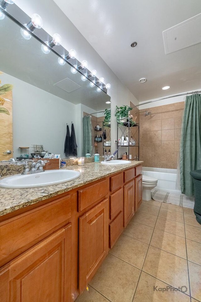 full bathroom with tile patterned floors, toilet, double vanity, and shower / bath combo with shower curtain