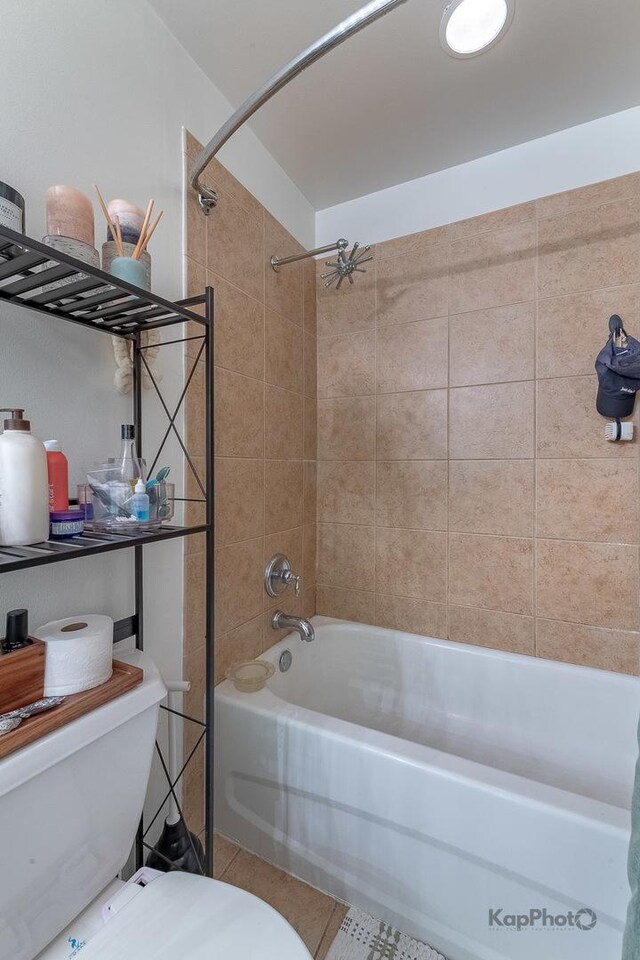 bathroom featuring toilet, bathing tub / shower combination, and tile patterned floors