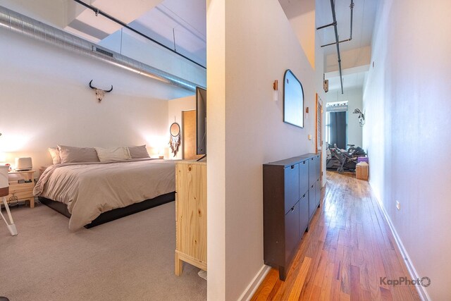 bedroom with light wood-type flooring and baseboards