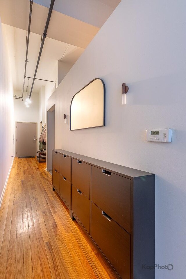 hall with light wood-type flooring and baseboards