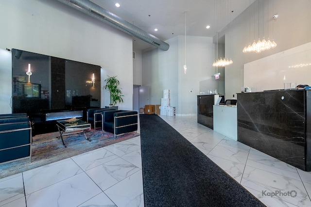 reception area with a high ceiling, recessed lighting, and a chandelier