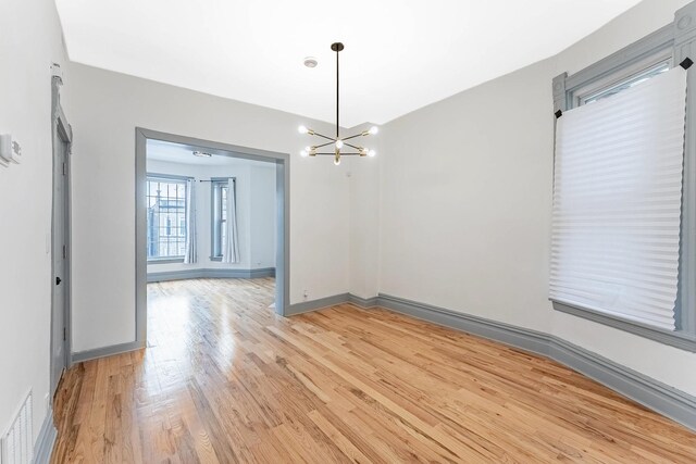 6602 S Marquette Ave, Chicago, IL 60637 - unfurnished dining area with light wood-style floors, a chandelier, and baseboards