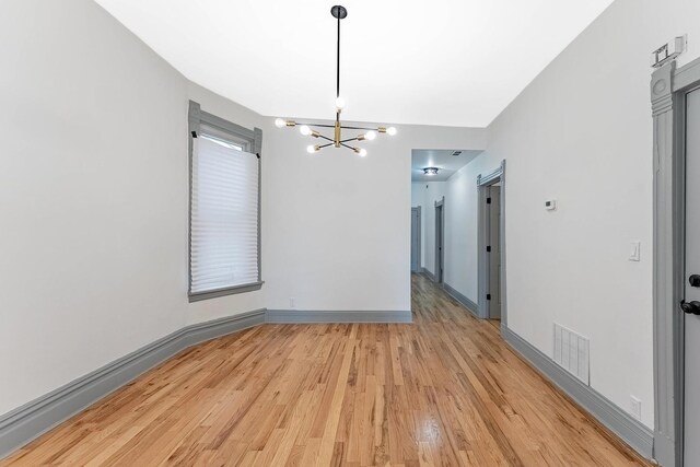 6602 S Marquette Ave, Chicago, IL 60637 - unfurnished dining area featuring a chandelier, light wood finished floors, and baseboards
