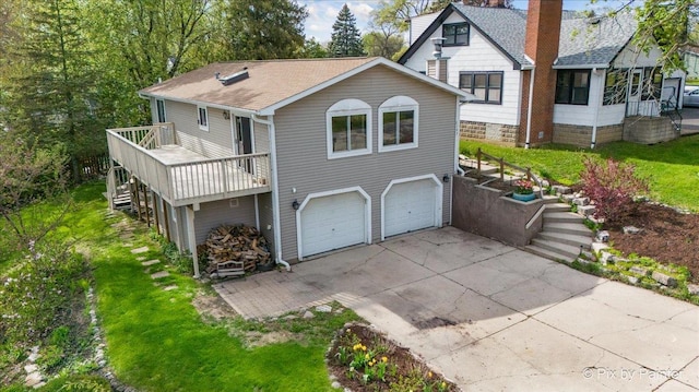 1109 Adams Ave, Wauconda, IL 60084 - back of property featuring an attached garage, concrete driveway, stairs, a deck, and roof with shingles