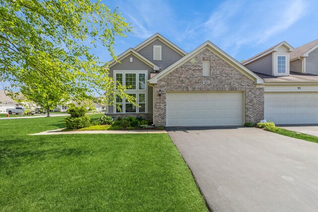 101 Boathouse Rd, Pingree Grove, IL 60140 - traditional-style home featuring a front lawn, asphalt driveway, brick siding, and a garage