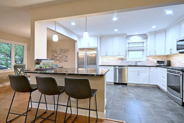 741 E Division St, Lombard, IL 60148 - kitchen with appliances with stainless steel finishes, a sink, a kitchen breakfast bar, tasteful backsplash, and recessed lighting