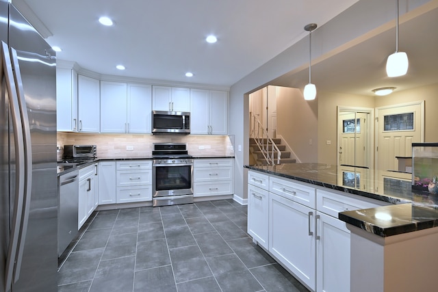 741 E Division St, Lombard, IL 60148 - kitchen featuring stainless steel appliances, backsplash, white cabinets, dark tile patterned flooring, and hanging light fixtures