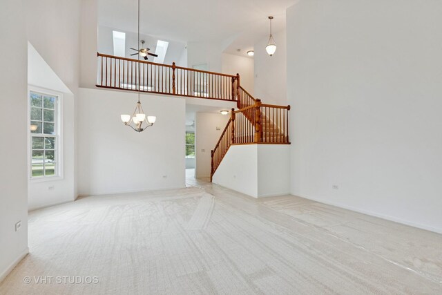 16306 Windsor Lake Ct, Crest Hill, IL 60403 - unfurnished living room with carpet flooring, a towering ceiling, a chandelier, stairs, and a skylight