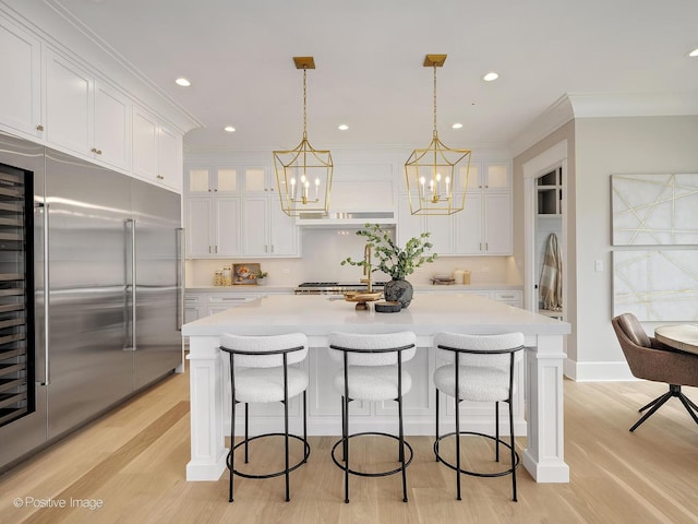 228 S Adams St, Hinsdale, IL 60521 - kitchen with built in fridge, white cabinetry, light countertops, light wood-style flooring, and a chandelier