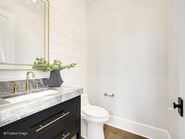 228 S Adams St, Hinsdale, IL 60521 - half bathroom with toilet, wood finished floors, vanity, baseboards, and wood walls