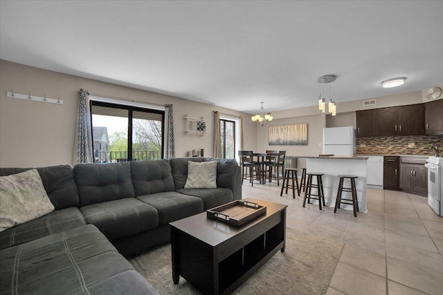 463 Valley Dr Unit 303, Naperville, IL 60563 - living room featuring a chandelier, light tile patterned floors, and a wall unit AC