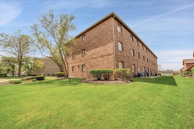 463 Valley Dr Unit 303, Naperville, IL 60563 - view of home's exterior featuring brick siding, a lawn, and central AC