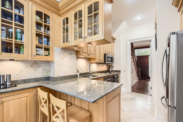2153 N Sedgwick St, Chicago, IL 60614 - kitchen with appliances with stainless steel finishes, a sink, light tile patterned floors, baseboards, and a kitchen bar