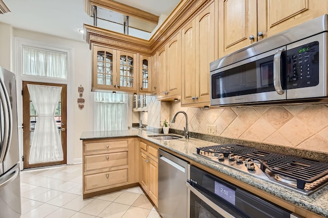 2153 N Sedgwick St, Chicago, IL 60614 - kitchen featuring stainless steel appliances, tasteful backsplash, light tile patterned floors, light stone counters, and a sink
