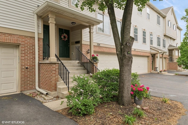 326 Southwicke Dr, Streamwood, IL 60107 - property entrance featuring brick siding, a garage, and driveway