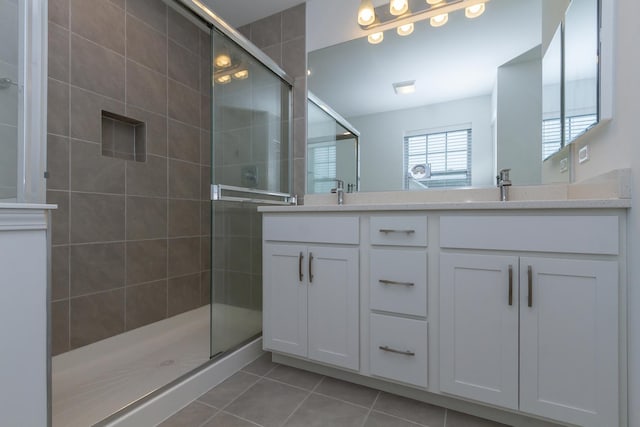 full bath featuring tile patterned flooring, a shower stall, and double vanity