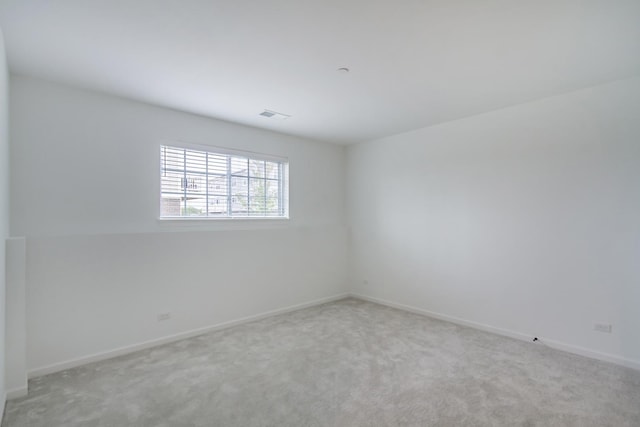 spare room featuring carpet and baseboards