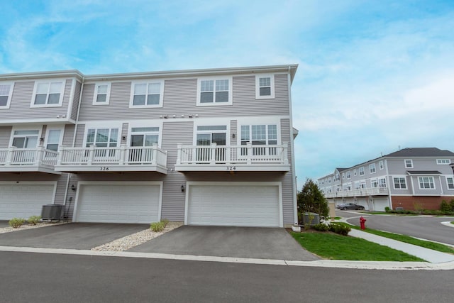 townhome / multi-family property with central AC, an attached garage, and driveway