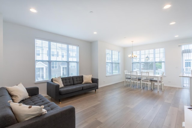 living area with a chandelier, baseboards, light wood-type flooring, and recessed lighting