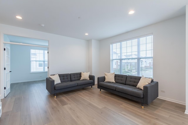 living area with light wood finished floors, baseboards, and recessed lighting