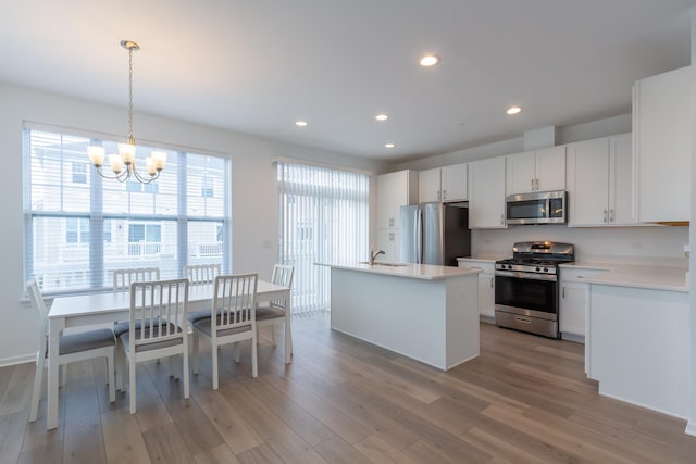 kitchen featuring appliances with stainless steel finishes, a chandelier, light wood-style floors, light countertops, and recessed lighting