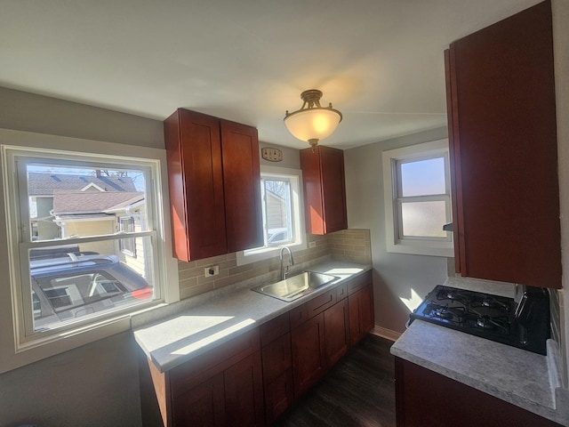 442 Hickory Pl, Elgin, IL 60120 - kitchen featuring a sink, dark wood-style flooring, range with gas stovetop, decorative backsplash, and baseboards