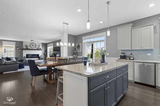 16436 S Mueller Cir, Plainfield, IL 60586 - kitchen with stainless steel dishwasher, a stone fireplace, white cabinets, dark wood finished floors, and recessed lighting
