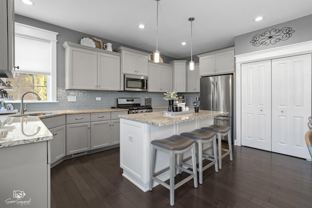 16436 S Mueller Cir, Plainfield, IL 60586 - kitchen with stainless steel appliances, a sink, decorative backsplash, dark wood-style floors, and a kitchen island