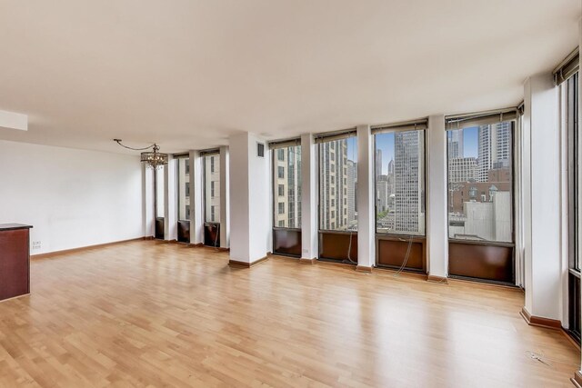 100 E Walton St Unit 25F, Chicago, IL 60611 - spare room featuring light wood finished floors, a chandelier, and healthy amount of natural light