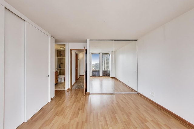 100 E Walton St Unit 25F, Chicago, IL 60611 - unfurnished bedroom featuring light wood-style flooring, multiple closets, and baseboards