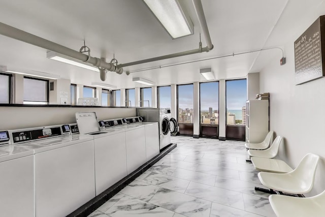 100 E Walton St Unit 25F, Chicago, IL 60611 - community laundry with washer and clothes dryer, light marble finish flooring, and a view of city