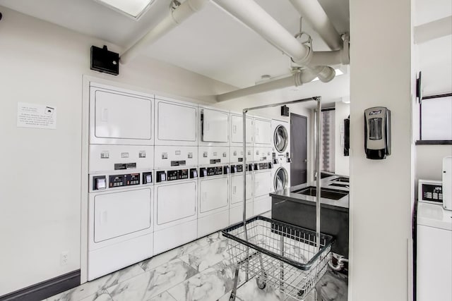 100 E Walton St Unit 25F, Chicago, IL 60611 - community laundry featuring stacked washer / dryer and light marble finish flooring