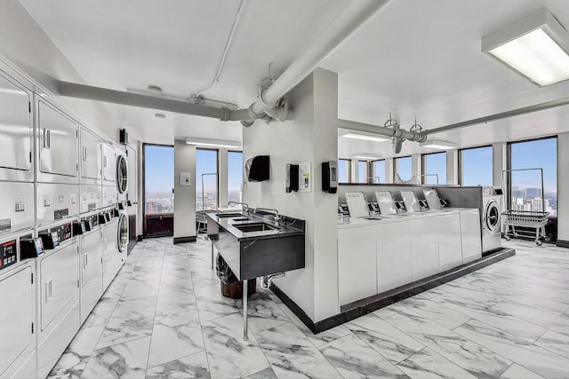 100 E Walton St Unit 25F, Chicago, IL 60611 - living room with estacked washer and dryer, light marble finish flooring, washer and dryer, and baseboards