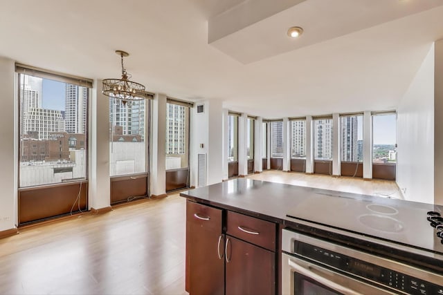 100 E Walton St Unit 25F, Chicago, IL 60611 - kitchen with stainless steel oven, light wood-type flooring, a chandelier, electric cooktop, and hanging light fixtures