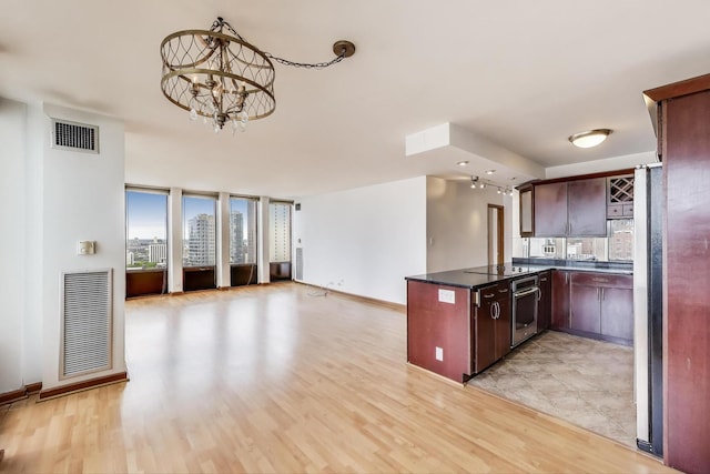 100 E Walton St Unit 25F, Chicago, IL 60611 - kitchen with open floor plan, a chandelier, light wood-style floors, and a peninsula