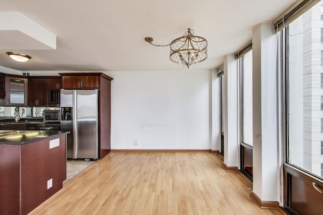 100 E Walton St Unit 25F, Chicago, IL 60611 - kitchen with stainless steel appliances, healthy amount of natural light, dark countertops, and light wood-type flooring
