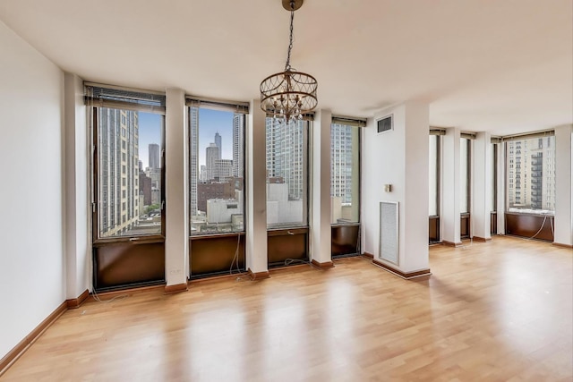 100 E Walton St Unit 25F, Chicago, IL 60611 - empty room with wood finished floors, a chandelier, baseboards, and a view of skyline