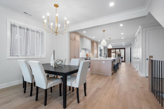 dining room with a chandelier, light wood-style floors, crown molding, recessed lighting, and baseboards