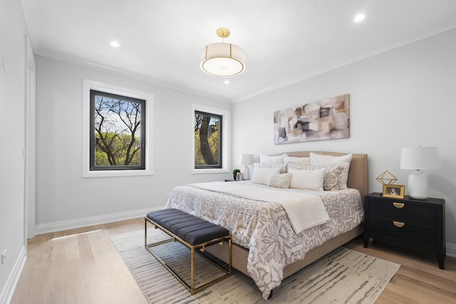 bedroom with light wood-style floors, crown molding, baseboards, and recessed lighting