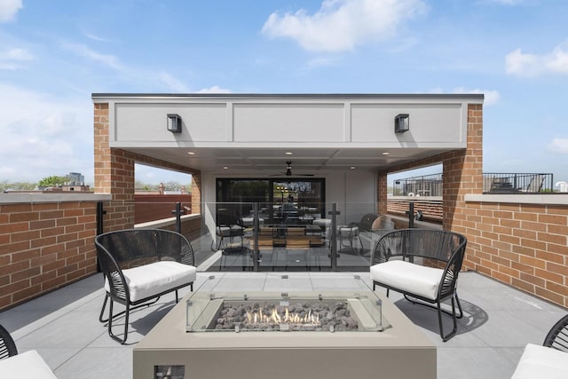 view of patio with an outdoor living space with a fire pit