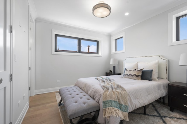 bedroom with wood finished floors, baseboards, ornamental molding, and recessed lighting