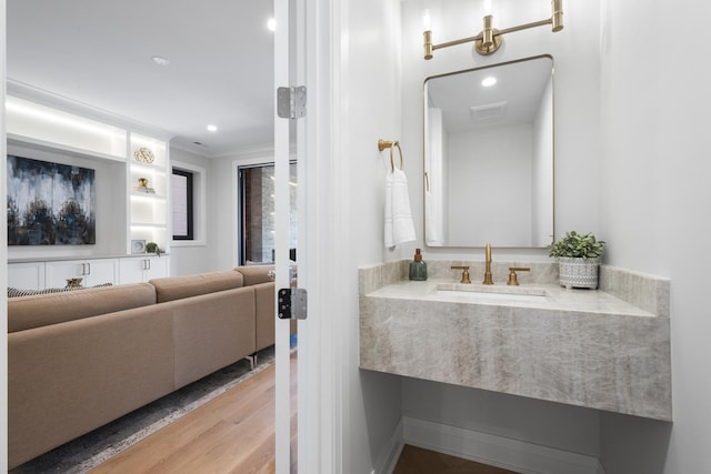 bathroom with wood finished floors, vanity, and recessed lighting