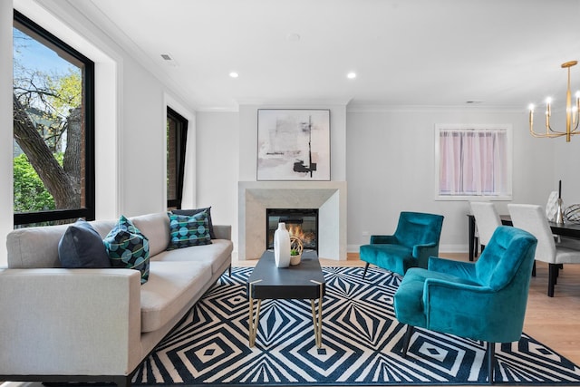 living area with a chandelier, ornamental molding, wood finished floors, a fireplace, and recessed lighting