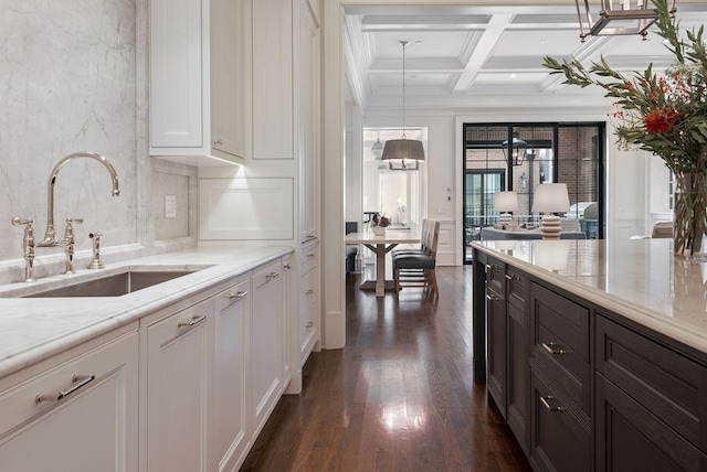 1534 N Dearborn Pkwy, Chicago, IL 60610 - kitchen with a sink, dark wood-type flooring, white cabinets, beam ceiling, and crown molding