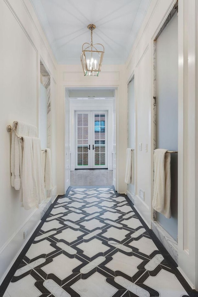 1534 N Dearborn Pkwy, Chicago, IL 60610 - hallway featuring inlaid floor details, french doors, a chandelier, baseboards, and crown molding