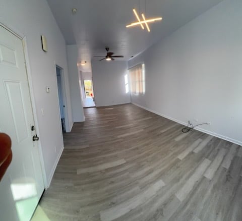 7941 S Woodlawn Ave, Chicago, IL 60619 - unfurnished living room with wood finished floors, baseboards, and ceiling fan