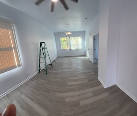 7941 S Woodlawn Ave, Chicago, IL 60619 - unfurnished living room with wood finished floors, ceiling fan, and baseboards