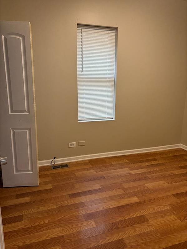 7941 S Woodlawn Ave, Chicago, IL 60619 - spare room featuring wood finished floors and baseboards